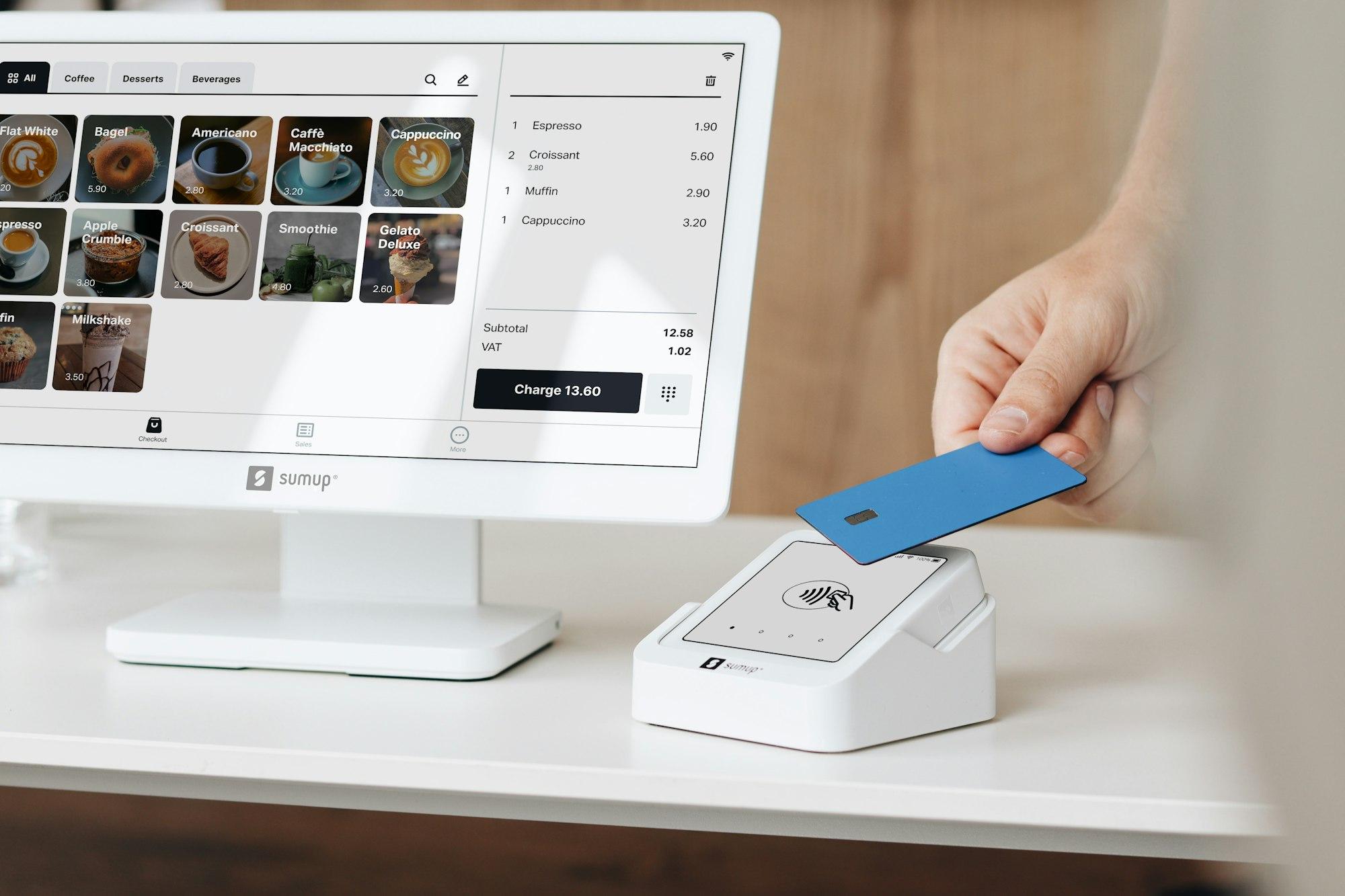 A customer tapping their card on a reader next to the till